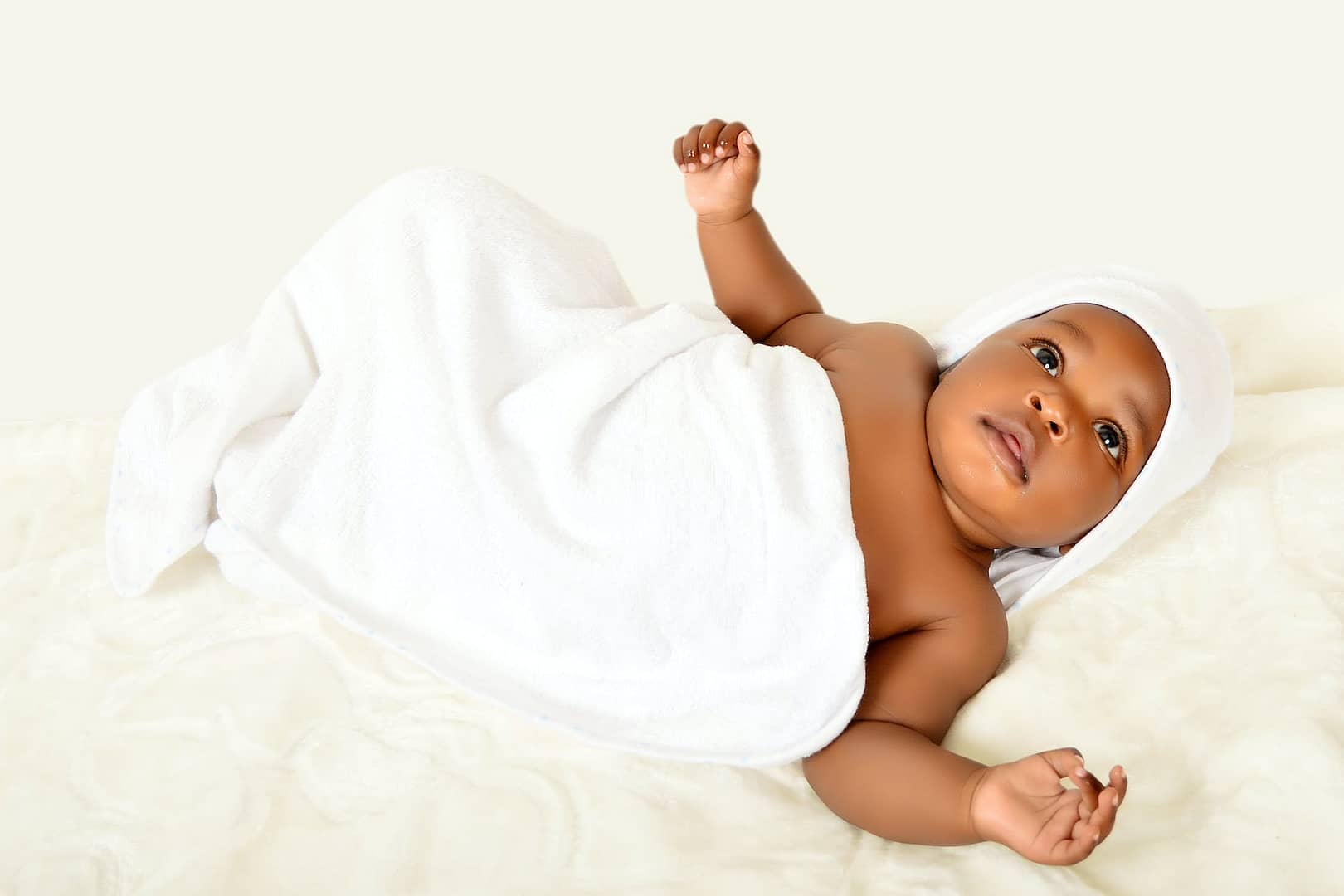 white blanket on top of an adorable baby