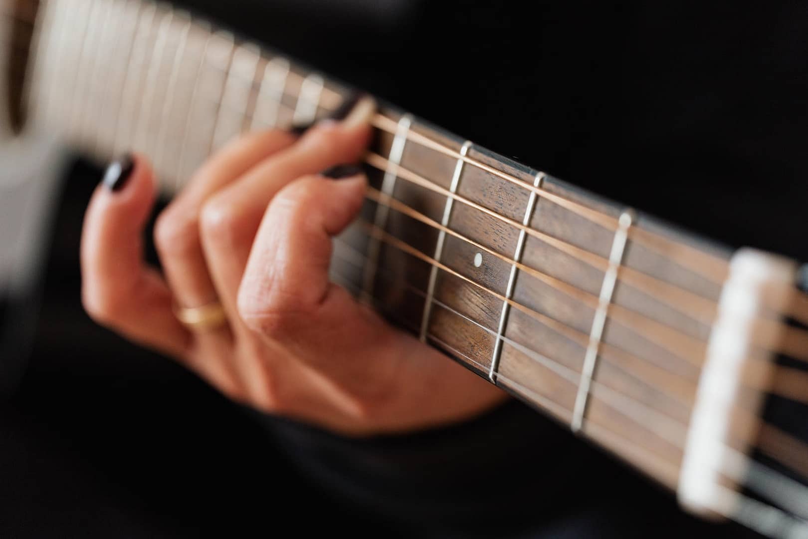 crop faceless woman practicing classical guitar technique