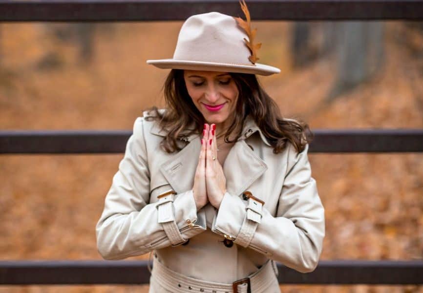 a woman in a coat praying